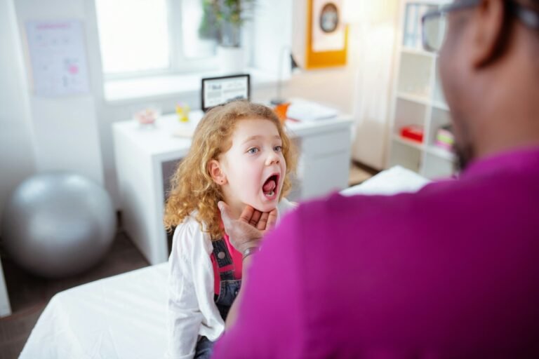 Doctor is examining baby's throat.