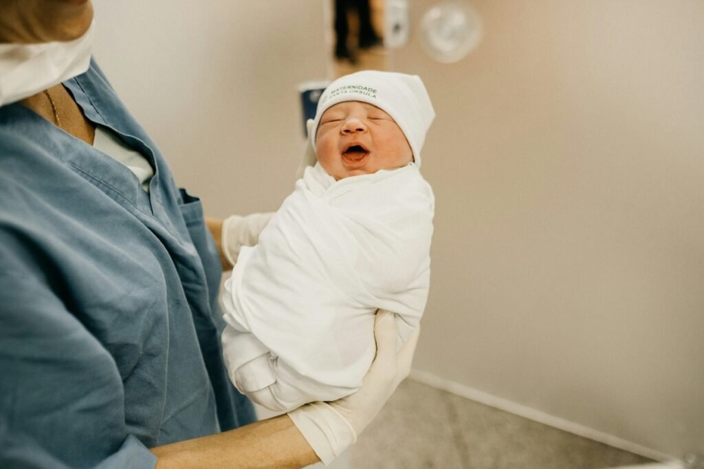 Newborn baby in nurse's hand.