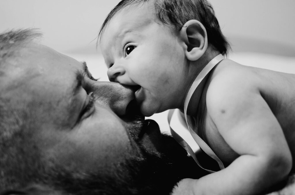 Baby smooching father.