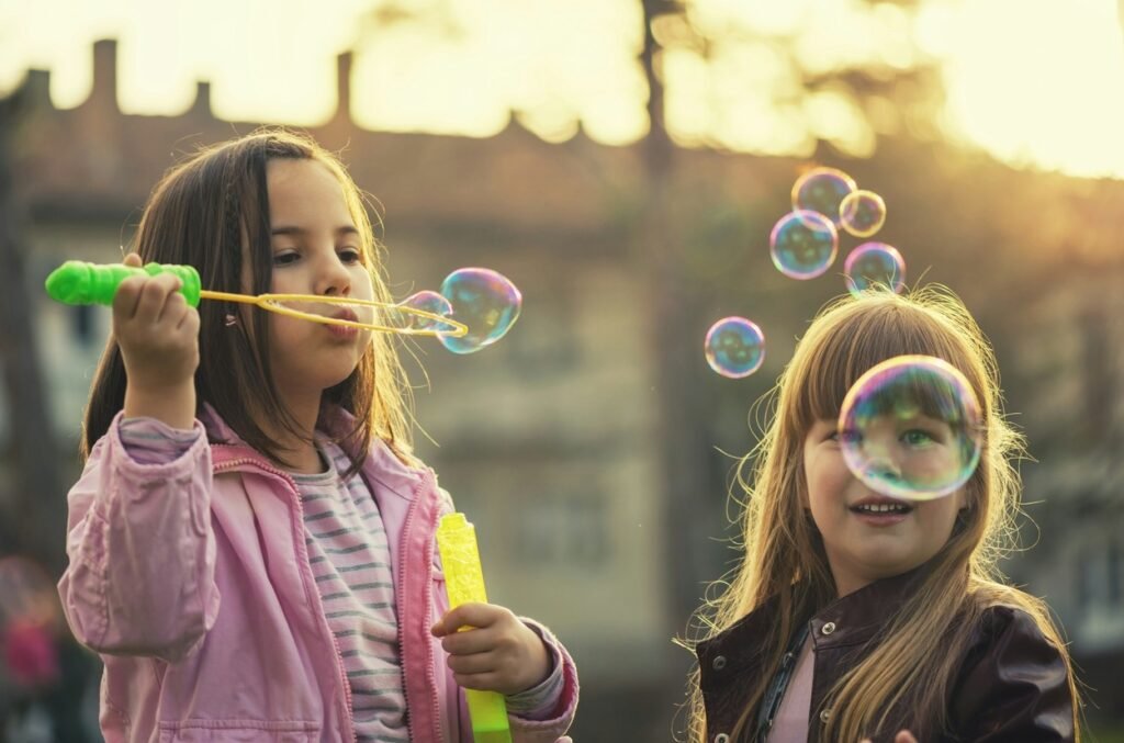 Two little girls playing with bubbles.