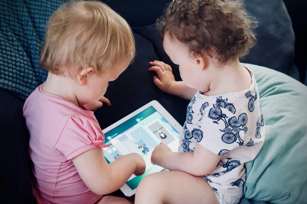 Two little kids reading a book together.