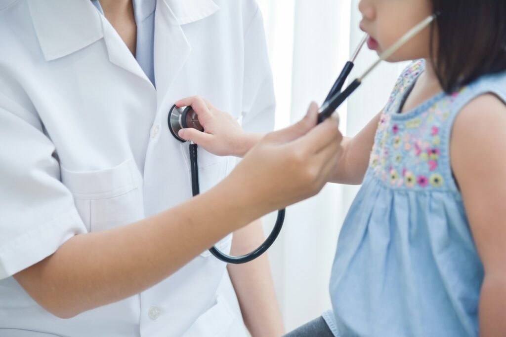 Pediatrician checking little girl. 