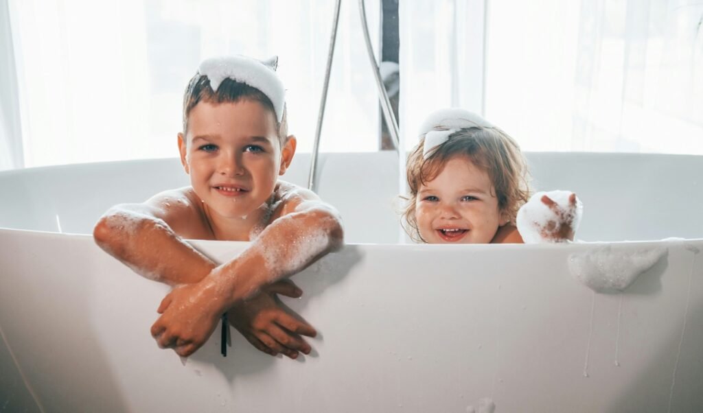 Two sibling enjoying bubble bath.