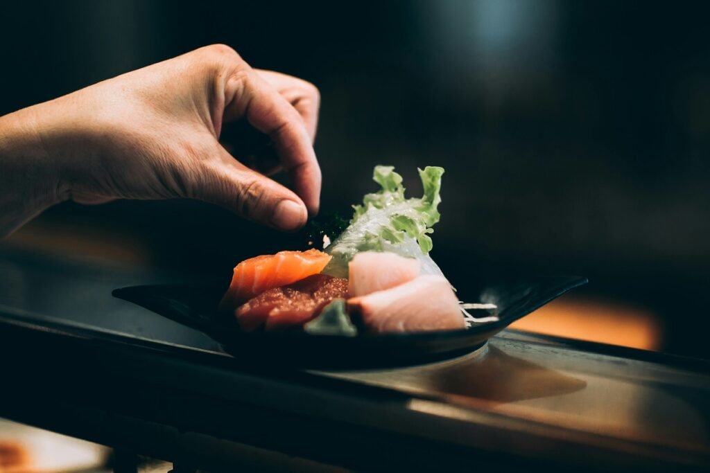 Left hand picking vegetable from a plate.