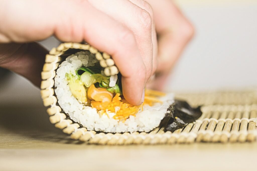 A person is rolling up sushi.