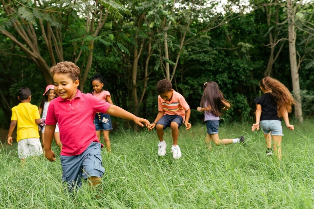 Little kids are playing in a field.