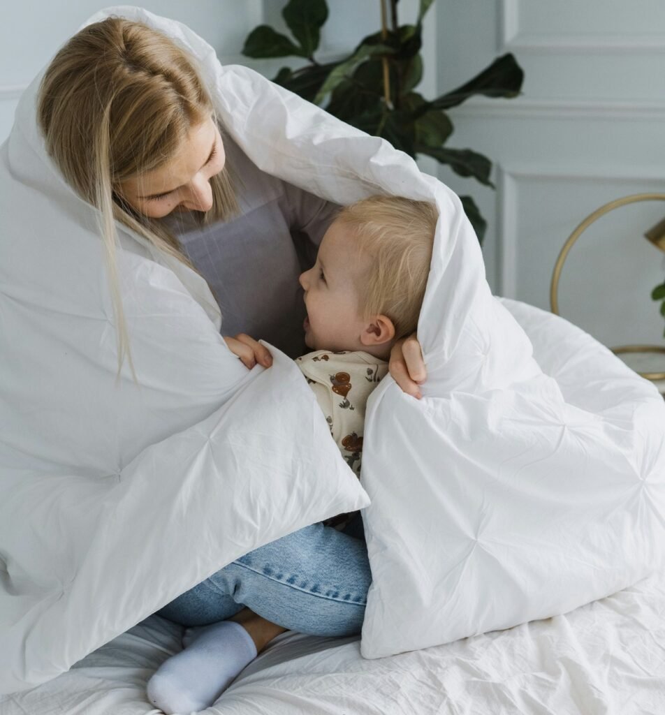 Mother and children are lying under the bed. 