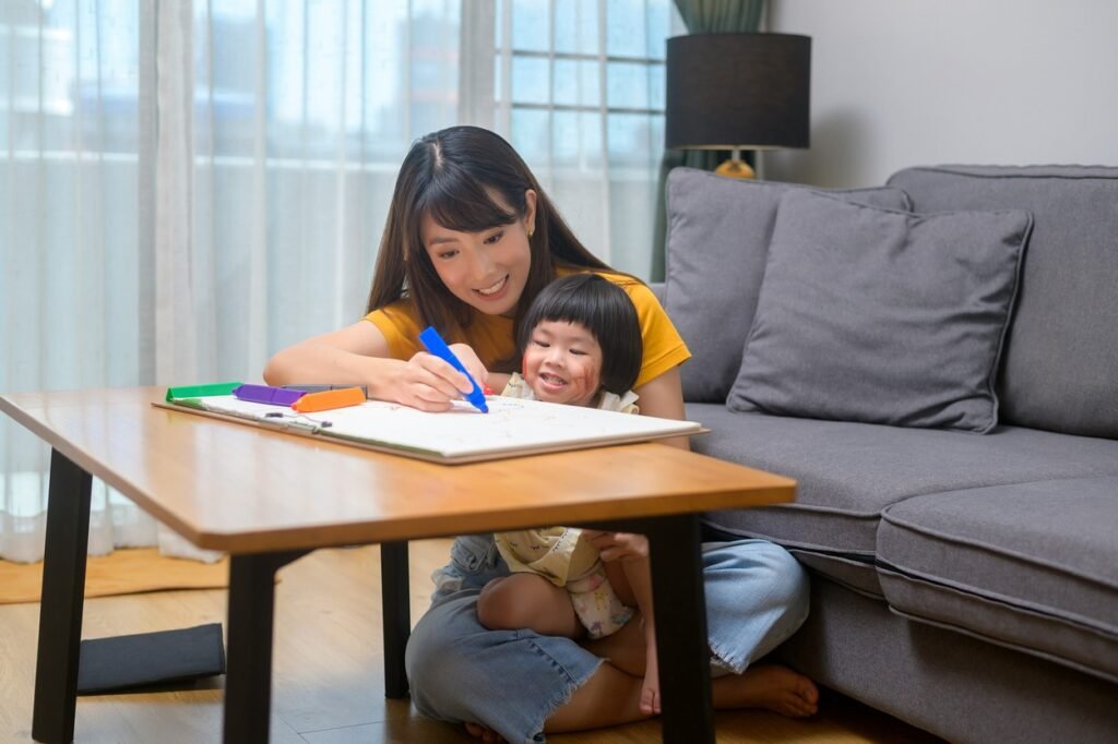 Mother helping little baby in coloring.