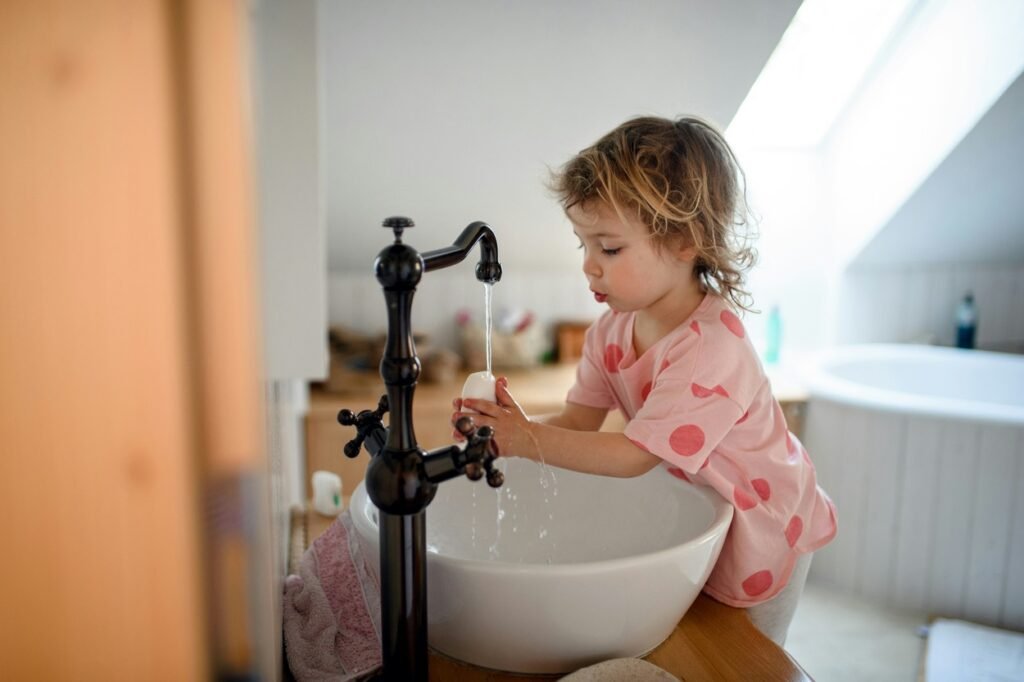 Little girl washing her hand with soap.