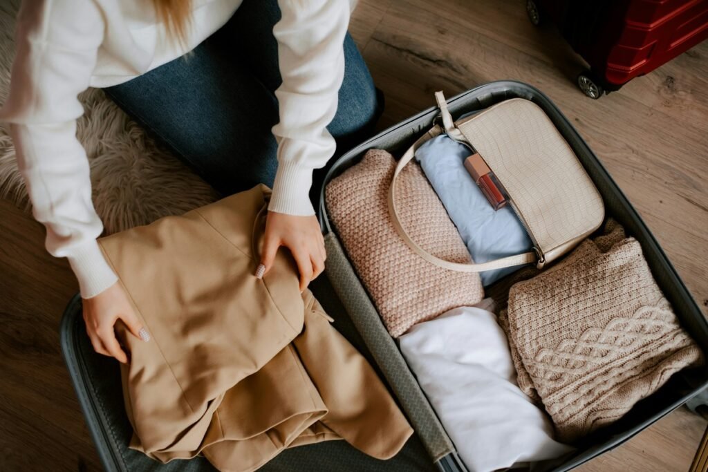 A woman arranging her clothes in a luggage.