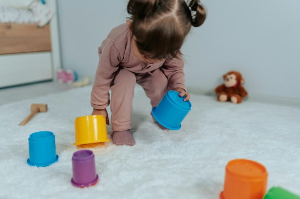 Baby playing with colorful tubs.