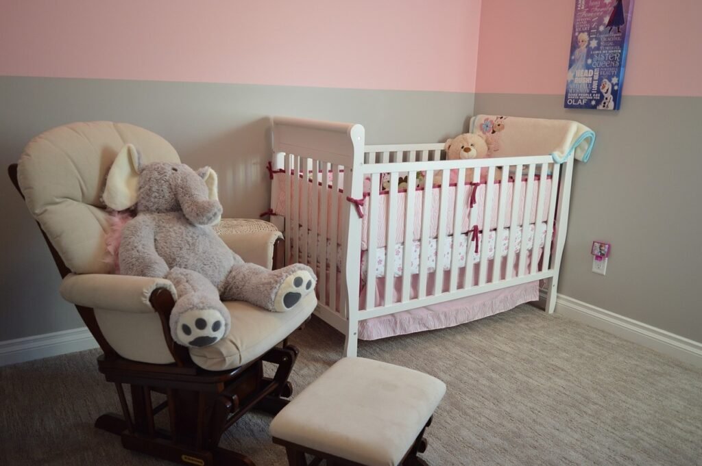 A baby bed with a rocking chair by its side.