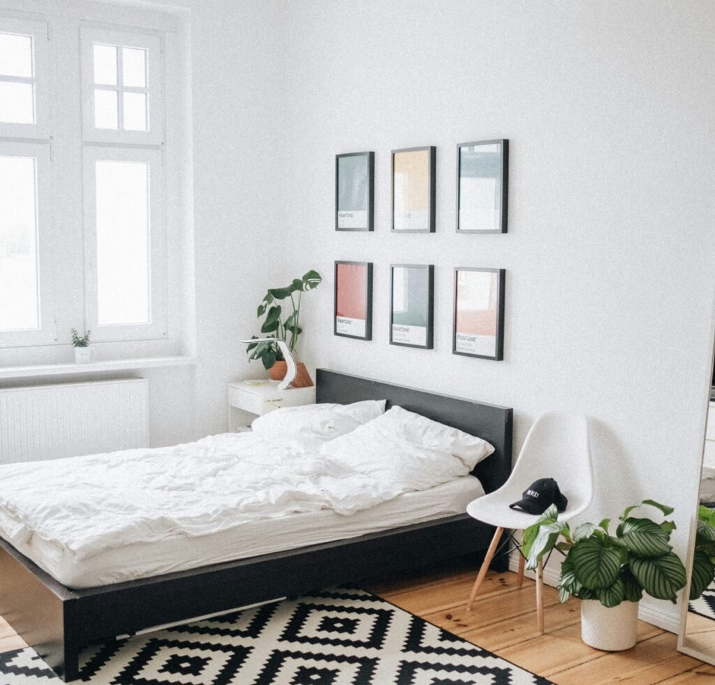 Twin bed with a beautiful plane and a white chair beside.