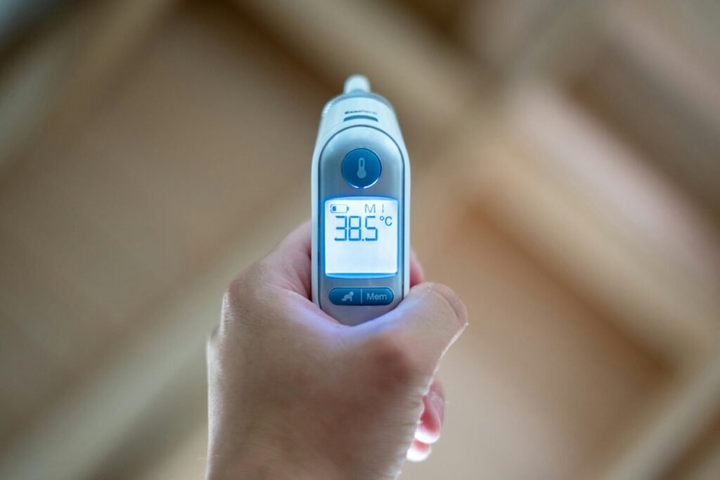 A person holding a thermometer in their hand.